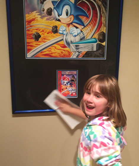 Dan’s daughter dusts off one of the pieces in his collection; the original art from Sonic Spinball for Sega Genesis. Photo courtesy ‘Bronty’